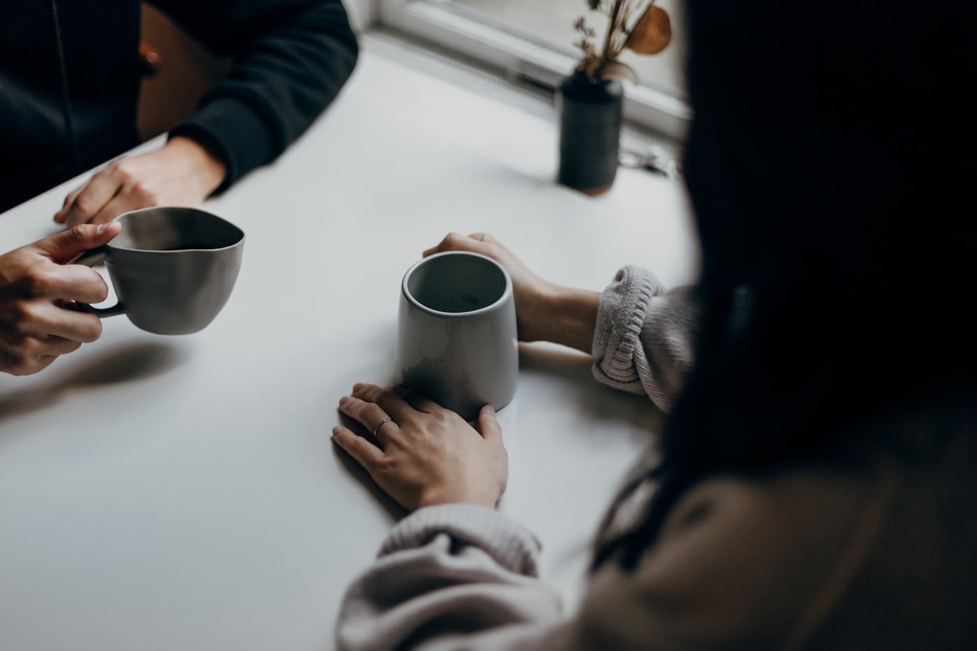 Two people holding hands in a supportive conversation